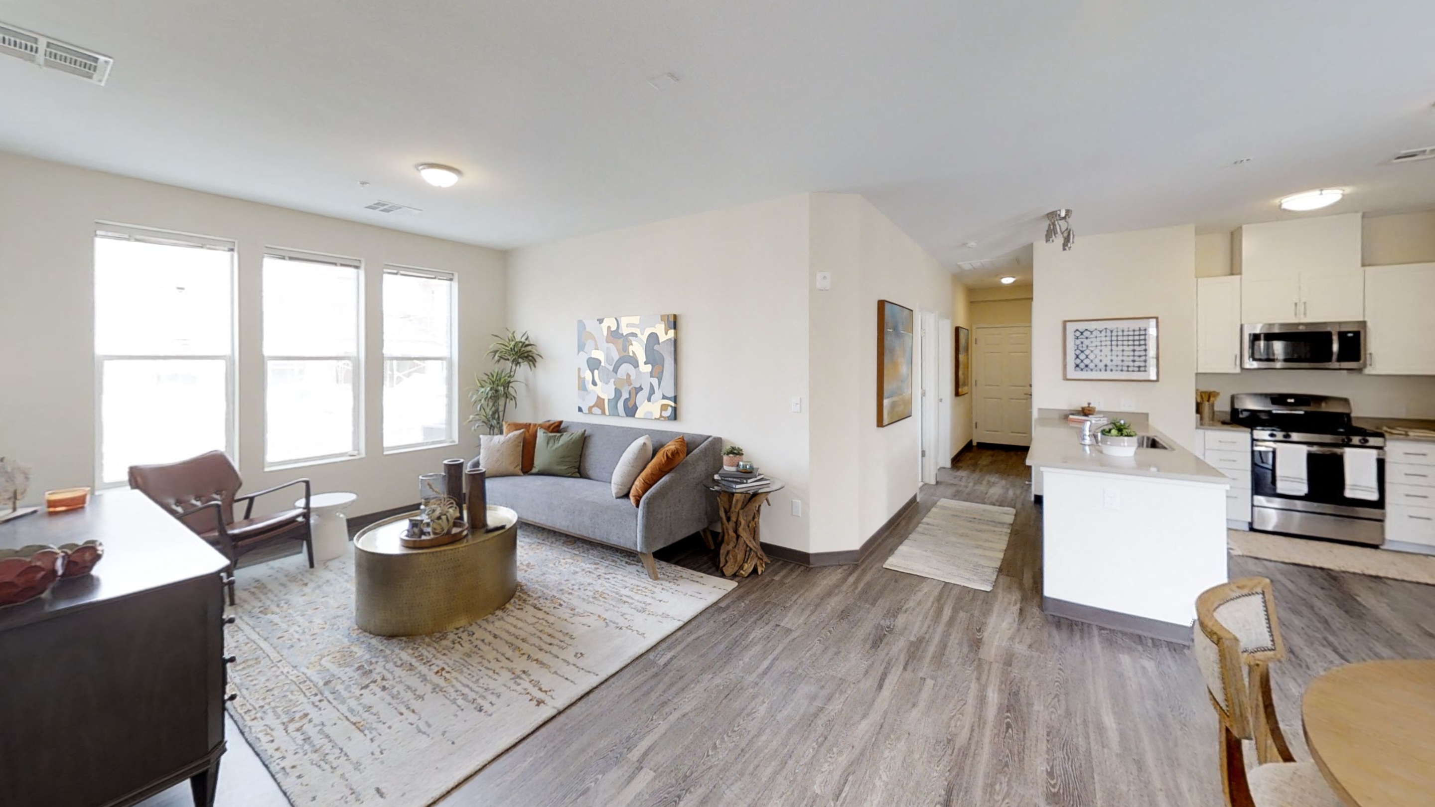 a living room and kitchen with a couch and a table